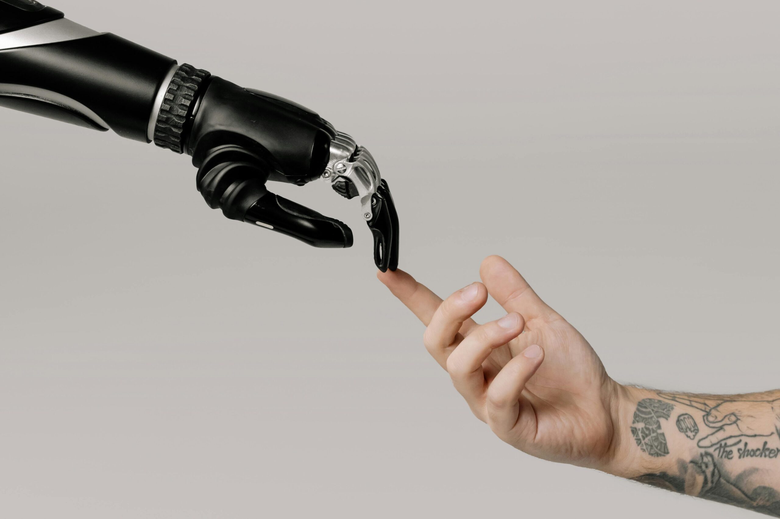 Human hand touching a robotic hand, symbolizing MSP automation. Visual metaphor for replacing manual MSP tasks with automation tools that save time and reduce tech burnout.